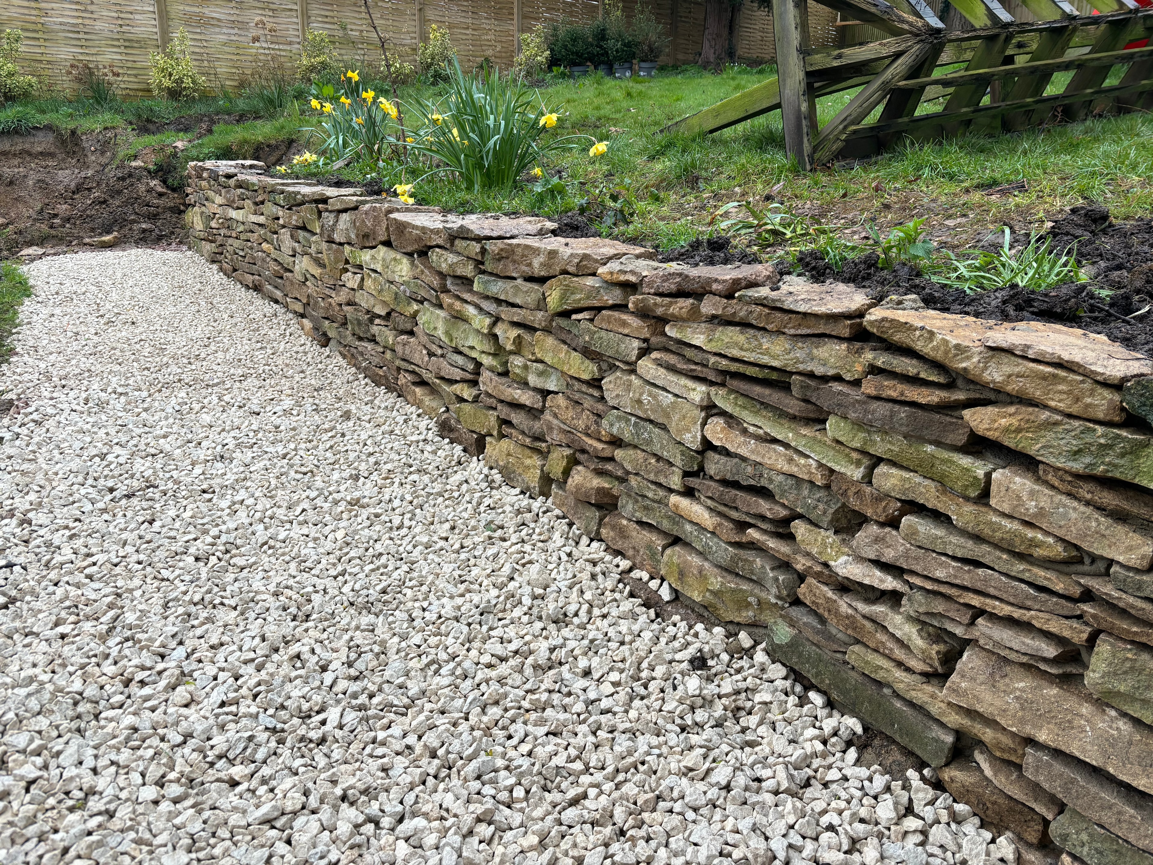 Dry stone retaining wall with gravel path