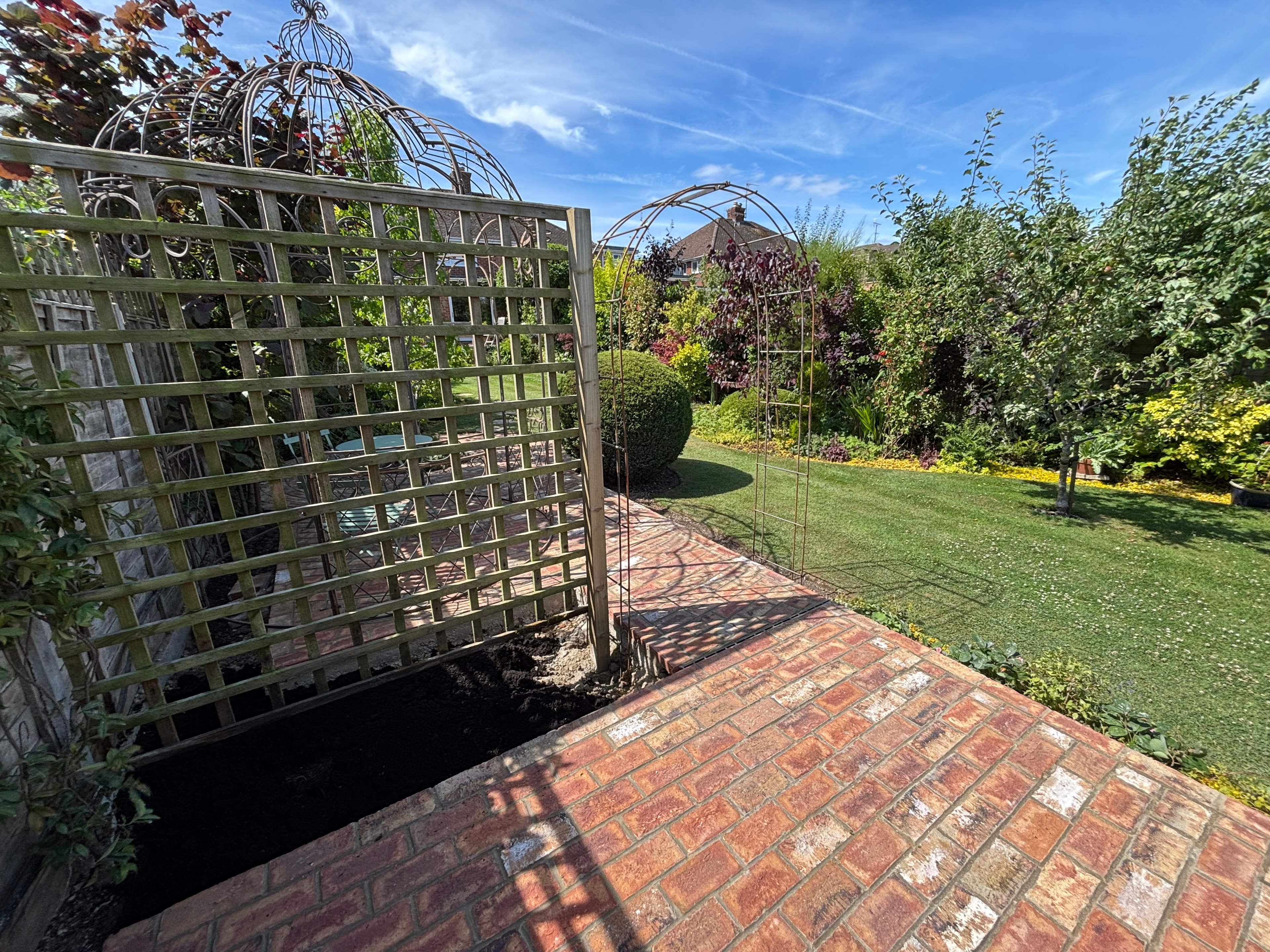 Garden with trellis panels and brick pathway